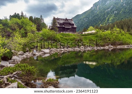 Chalet on the shore of Lake Morskie Oko in the Polish Tatra National Park. The lake is located in the mountains and reflects the surrounding peaks and trees. This image is perfect for nature, travel