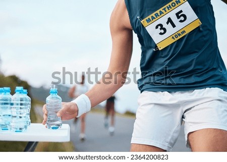 Hand, water and running a marathon race for competition closeup with fitness or cardio on a street. Sports, exercise or health and a runner or athlete person with a drink while on a road for training Royalty-Free Stock Photo #2364200823