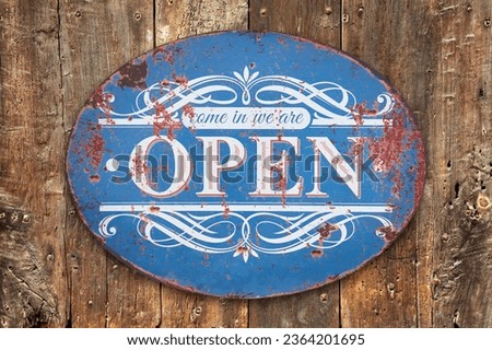 Come in we are open sign on a weathered old wooden background