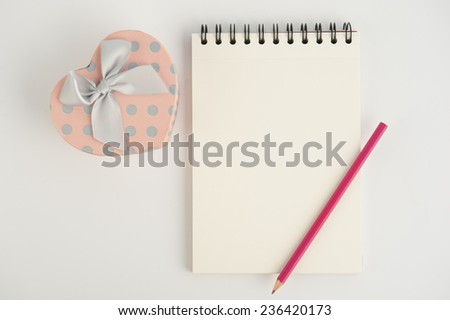 Heart gift box and notebook pencil  on  white background
