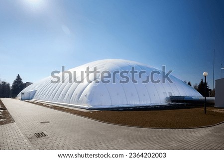 Inflatable air dome stadium. Inflated Tennis air dome or Tennis bubble arena. Modern urban architecture example as pneumatic stadium dome. Royalty-Free Stock Photo #2364202003
