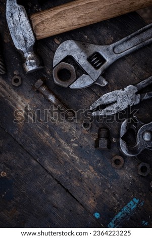 Old work tools nuts, bolts and bearings lie on a wooden workbench