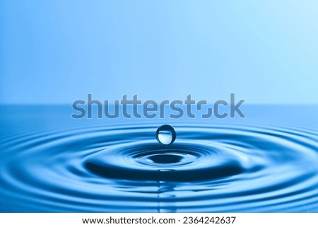 Group of water droplets fall and bounce on a water surface       