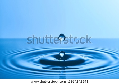 Group of water droplets fall and bounce on a water surface       