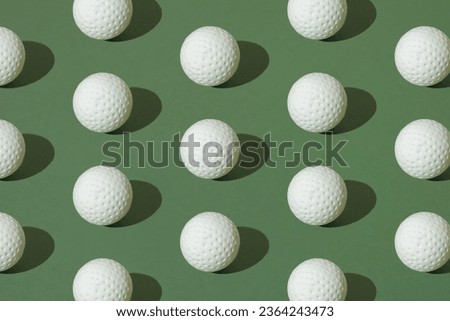 White golf ball on a green pastel background. Pattern.