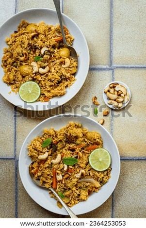 Biryani in plate with lime on yellow background. Flat lay photography.
