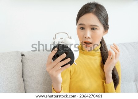 Shocked Asia young woman looking at clock alarm, lady is late appointment or work or class study, overslept, difficulty get up in mornings, time worried, not on time, sleepy, over due, Hurry up time Royalty-Free Stock Photo #2364270461