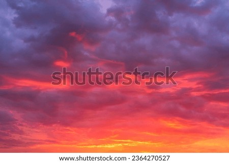 Glowing sky at sunset texture background overlay. Dramatic red, orange, and purple clouds. High resolution photography perfect for sky replacement