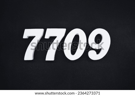 Black for the background. The number 7709 is made of white painted wood.