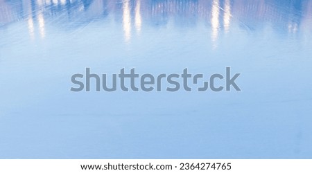 Shiny blue ice rink surface with reflections of lights. Background photo texture