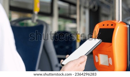Mobile payment concept, smart phone with empty screen in females hand pays bus travel using contactless technology of phone. Royalty-Free Stock Photo #2364296283
