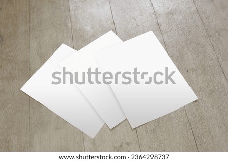 The set of a4 blank paper is isolated on the wooden floor, for brand identity printing presentation, business document template, document design showcase, or corporate marketing poster mockup.