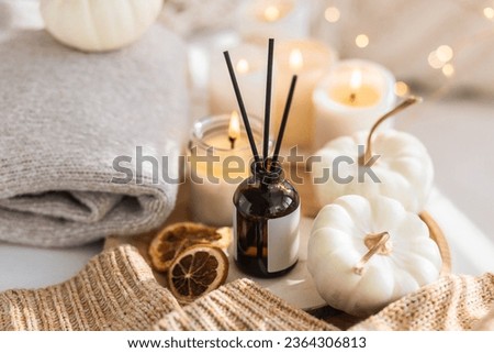 Cozy corner for home meditation and relaxation. Fall aroma diffuser with pumpkin pie scent, cinnamon, orange, burning candles for comfort, pleasure, aromatherapy. Apartment decor, house design Royalty-Free Stock Photo #2364306813