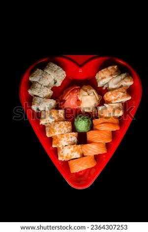 Heart shaped Valentine day sushi box. Sushi rolls philadelphia and california set for two for dating dinner on dark background.