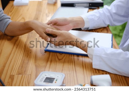 Male doctor's hand encouraging her female patient close-up, medical concept.