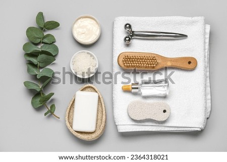 Composition with different bath supplies and eucalyptus branch on grey background