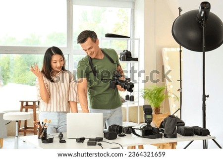 Male photographer and his assistant working in studio