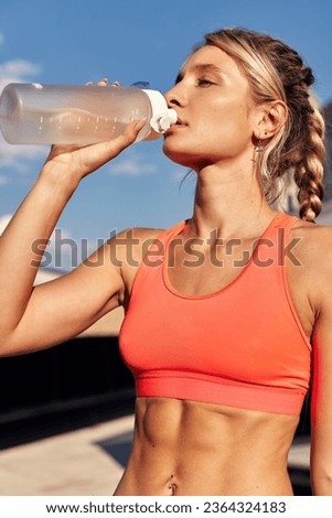 Maintaining hydration. A woman drinks water during a workout, replenishing her water-salt balance, beautiful light, a woman quenches her thirst on a sunny day Royalty-Free Stock Photo #2364324183