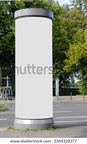 Empty advertising pillar in a city with white  free copy space, promotion mock up. Blank advertising panel