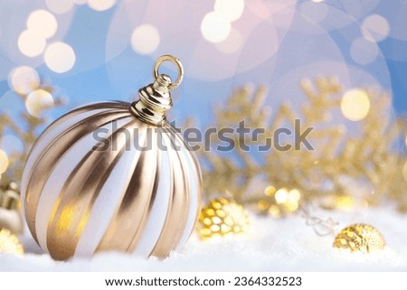 Christmas ball on a snow with decorations and flares, copy space