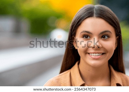 Closeup portrait of happy beautiful brunette hispanic young woman 20s posing outdoors, looking at copy space for text or advertisement, text. Offer for students, zoomers, blurred background