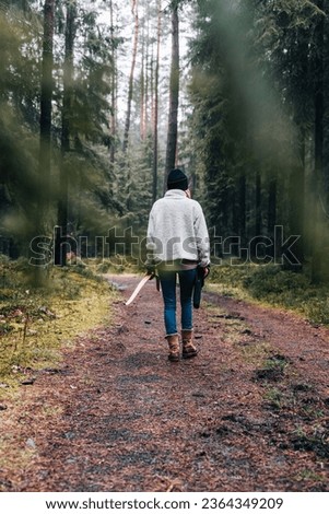 A person walking in a forest environment carrying archery equipment Royalty-Free Stock Photo #2364349209