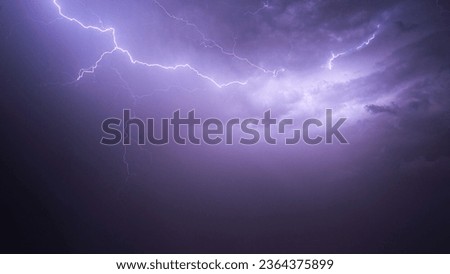 A stunning image of a night sky illuminated by two powerful lightning bolts as they crash down to the ground below