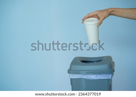Woman hand throwing empty paper coffee cup in recycling bin, Coffee or Breaking the Habit caffeine addiction concept Royalty-Free Stock Photo #2364377019
