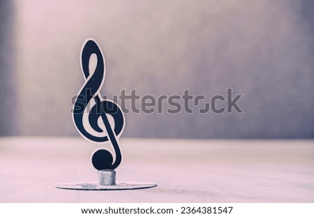 Photography of treble clef standing on desk in musical class room close up