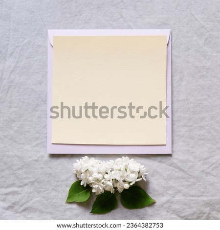 Happy birthday, mother's day, wedding composition. Blank greeting card, invitation and envelope mockup. Rectangular blank with delicate lilac flowers. Flat lay, top view.