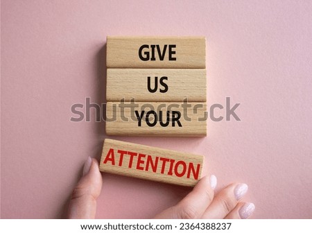 Attention symbol. Concept word Give us your attention on wooden blocks. Beautiful pink background. Businessman hand. Business and Give us your attention concept. Copy space