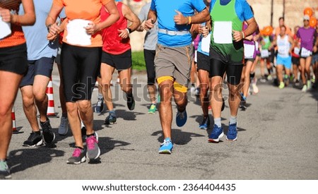 group of runners during the footrace in the street of the city Royalty-Free Stock Photo #2364404435
