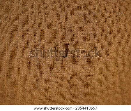 Letter J. Stamp letters on linen fabric