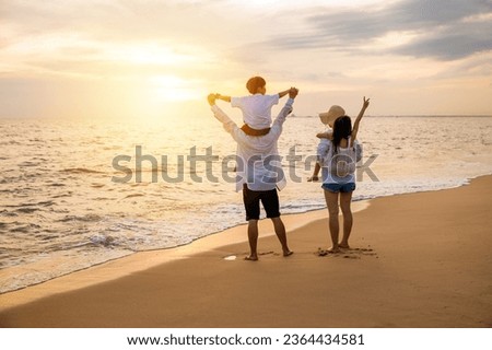 Happy family in holiday. Father, Mother and kids having fun together shoulder ride on summer beach, Parents carrying children on shoulders at beach on sunset time, Family on holiday summer vacation Royalty-Free Stock Photo #2364434581