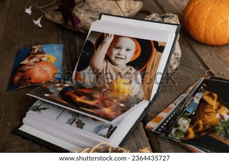 Open picture album with Halloween printed photos.