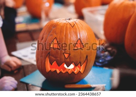 Process of making pumpkin lantern for halloween party, glowing jack-o-lantern carving master class on halloween fair market, orange decoration, illuminated carved pumpkin lanterns Royalty-Free Stock Photo #2364438657