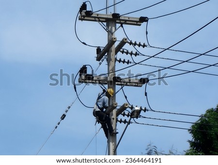 Electricians working on the electric post power pole for cleaning porcelain 22kV bushings Royalty-Free Stock Photo #2364464191
