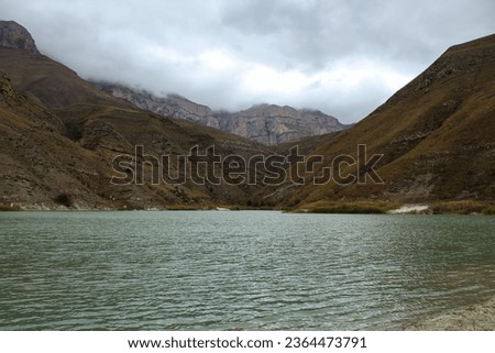 The beauty and peace of Lake Gizhgit, Russia. Picture of the shore from above, copy space for text, dramatic cloudy sky