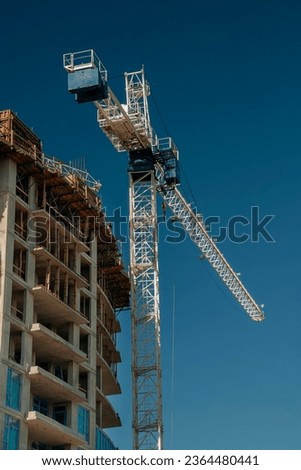 White crane towers at a large construction site of a glass building 