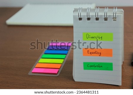Diversity Equality Conclusion written on a color sticky note on the note book with office desk as a background