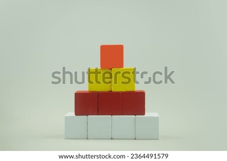 Colorful cubes wood cube arranged in pyramid shape on a white background.