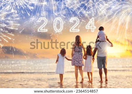 Happy new year. Crowd watching fireworks on tropical beach. Parents and kids celebrate new 2024 year. Holiday party in exotic destination. Winter vacation. Happy family with children at firework show. Royalty-Free Stock Photo #2364514857