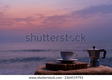 Close-up white coffee cup and many coffee beans placed around on wood table with a beautiful seascape of nature background, concept coffee vacation travel, beautiful morning light background.