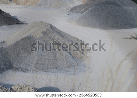 Pile of limestone and calcite white gravel. Close-up. Large gravel pit in a calcite quarry in Brno, Czechia. Industrial background. Plain, natural, rough background. Single color tone. Minimalist.