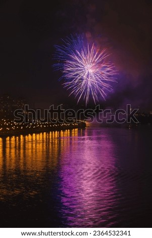 Colorful  bright fireworks, salute of various colors in night sky with reflection in lake. Abstract holiday background