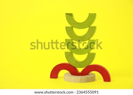 Colorful wooden pieces of playing set on yellow background, space for text. Educational toy for motor skills development