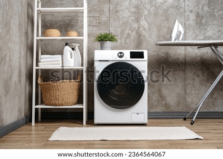 Washing machine in a gray modern laundry room Royalty-Free Stock Photo #2364564067