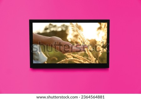 TV screen with movie frame on pink wall