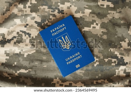 Ukrainian civil foreign passport on military camouflage pixel background. Border control