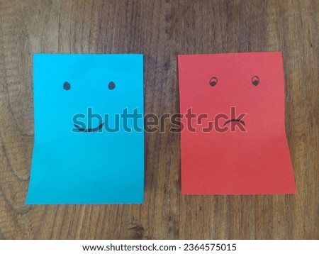 Two note cards stuck to the door leaf with smiles and sad cartoon facial expressions in happiness versus depression